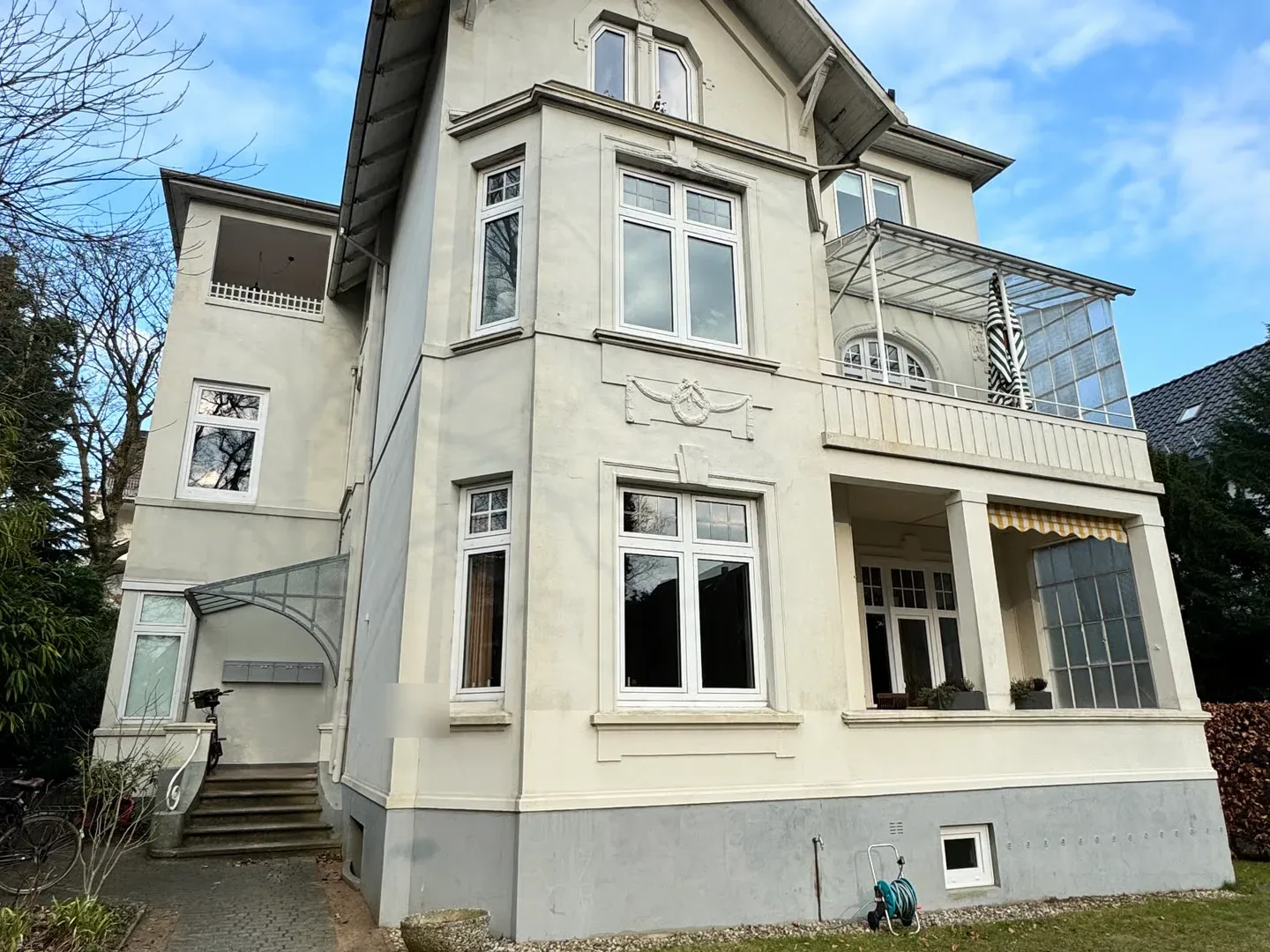 Villenartiges Mehrfamilienhaus in Hamburg-Blankenese mit heller Stuckfassade, Erker, Balkon und Wintergarten